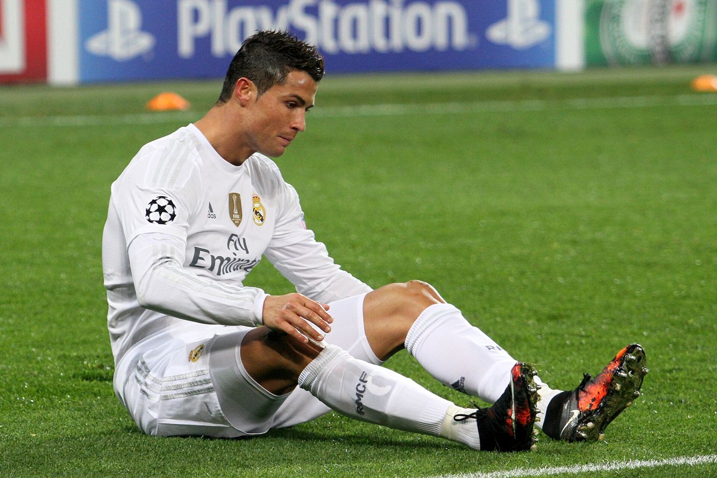 Cristiano Ronaldo sentado no gramado com a camisa do Real Madrid